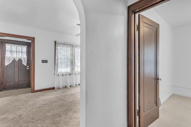 870 Bryant Ave, Jackson, MI 49202 - entrance foyer with light carpet, arched walkways, plenty of natural light, and baseboards