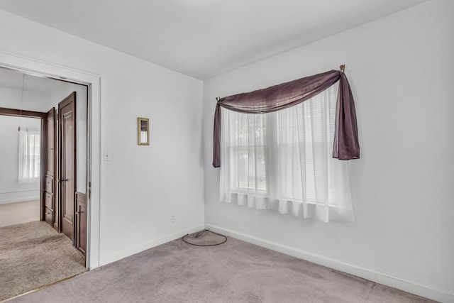 870 Bryant Ave, Jackson, MI 49202 - spare room with healthy amount of natural light, carpet floors, baseboards, and attic access