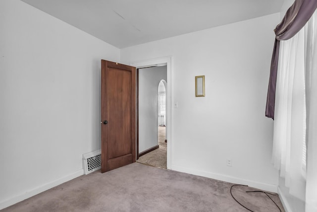 870 Bryant Ave, Jackson, MI 49202 - carpeted empty room featuring baseboards and arched walkways