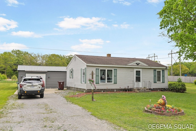 1070 Morningside St, Muskegon, MI 49442 - view of front of house with driveway, a chimney, and an outbuilding