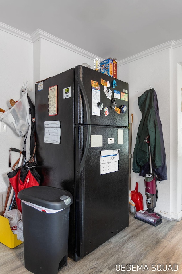 1070 Morningside St, Muskegon, MI 49442 - detailed view of freestanding refrigerator, wood finished floors, and ornamental molding