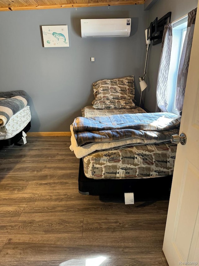 6111 Loud Dr, Oscoda, MI 48750 - bedroom featuring a wall mounted AC, wood finished floors, and baseboards