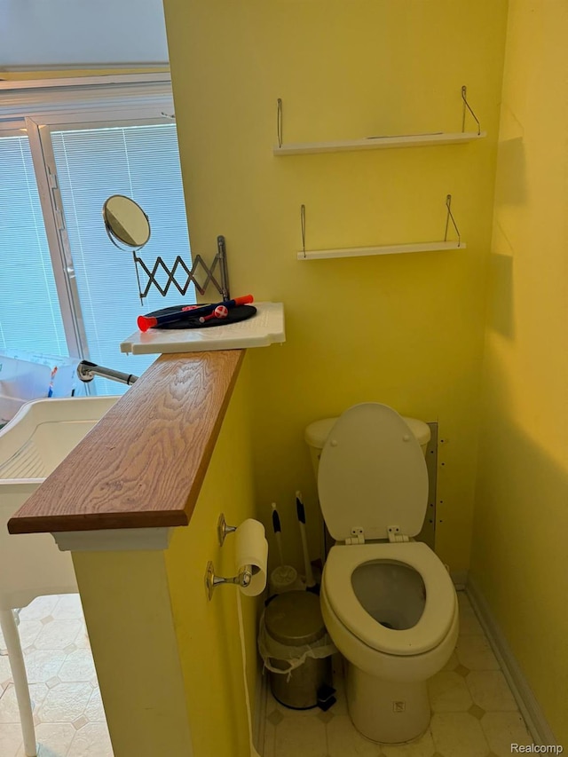 6111 Loud Dr, Oscoda, MI 48750 - bathroom featuring toilet, tile patterned floors, and baseboards