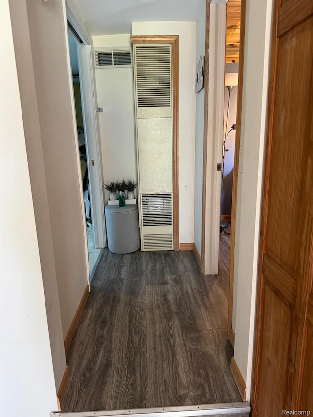 6111 Loud Dr, Oscoda, MI 48750 - corridor featuring a heating unit, dark wood-type flooring, and baseboards