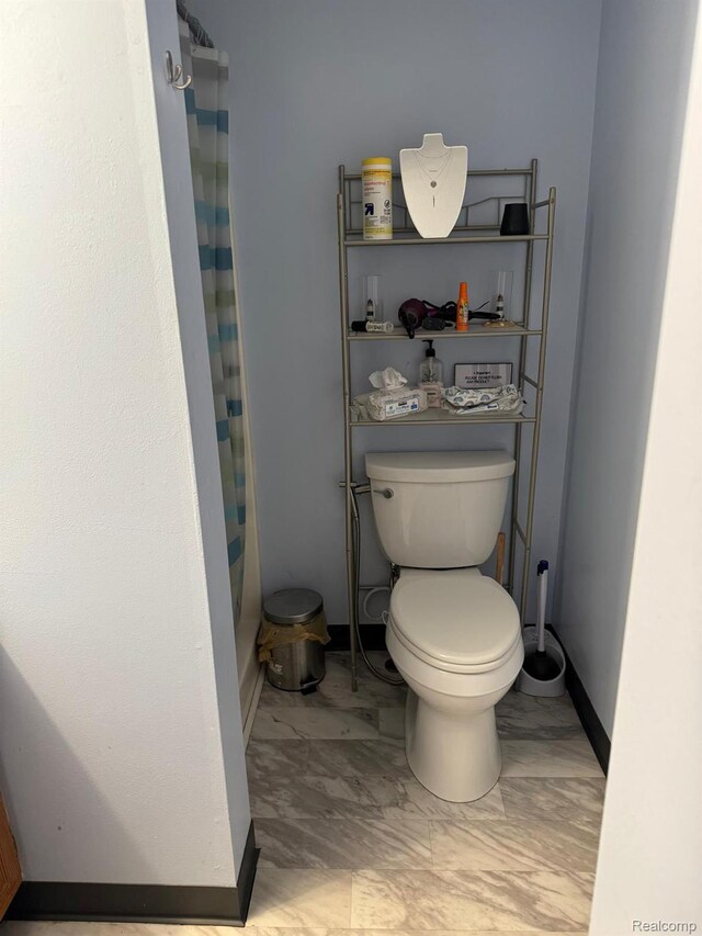 6111 Loud Dr, Oscoda, MI 48750 - bathroom with toilet, a shower with shower curtain, baseboards, and marble finish flooring
