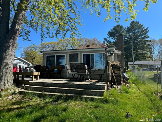 6111 Loud Dr, Oscoda, MI 48750 - back of property with a deck and a chimney