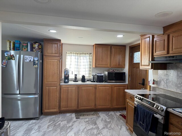 6111 Loud Dr, Oscoda, MI 48750 - kitchen featuring appliances with stainless steel finishes, under cabinet range hood, brown cabinets, healthy amount of natural light, and recessed lighting