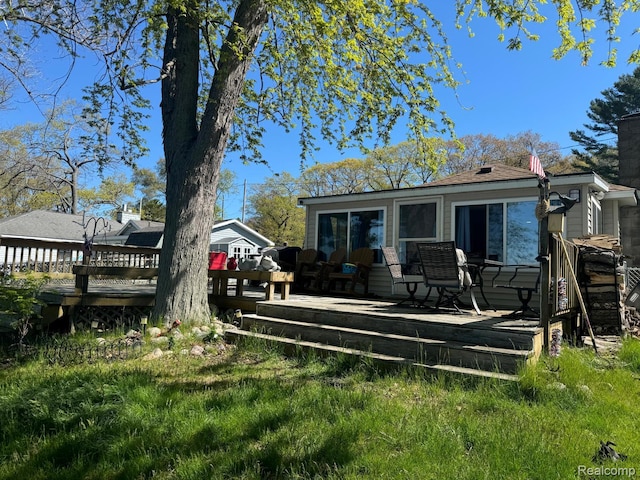 6111 Loud Dr, Oscoda, MI 48750 - back of house with a deck and a chimney