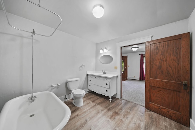 7331 Browns Lake Rd, Jackson, MI 49201 - bathroom with a soaking tub, vanity, wood finished floors, toilet, and baseboards