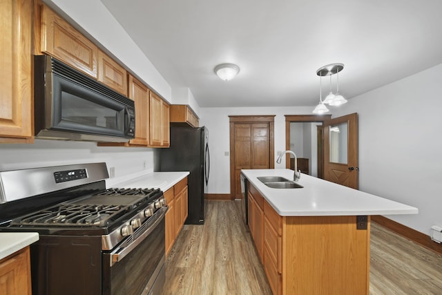 7331 Browns Lake Rd, Jackson, MI 49201 - kitchen with black appliances, a sink, light wood finished floors, baseboards, and light countertops