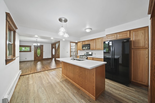 7331 Browns Lake Rd, Jackson, MI 49201 - kitchen featuring black appliances, a baseboard heating unit, a sink, a chandelier, and light countertops