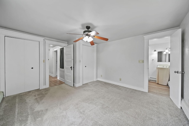 7331 Browns Lake Rd, Jackson, MI 49201 - unfurnished bedroom with multiple closets, a baseboard heating unit, carpet floors, and a ceiling fan