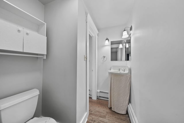7331 Browns Lake Rd, Jackson, MI 49201 - half bathroom with wood finished floors, toilet, a baseboard heating unit, vanity, and baseboards