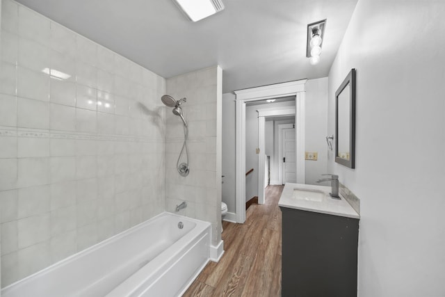 7331 Browns Lake Rd, Jackson, MI 49201 - bathroom featuring toilet, vanity, bathing tub / shower combination, wood finished floors, and baseboards