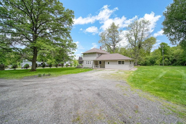 7331 Browns Lake Rd, Jackson, MI 49201 - view of front of house with driveway, a front lawn, and a chimney