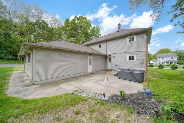 7331 Browns Lake Rd, Jackson, MI 49201 - back of house featuring a hot tub, a patio, a lawn, and a chimney