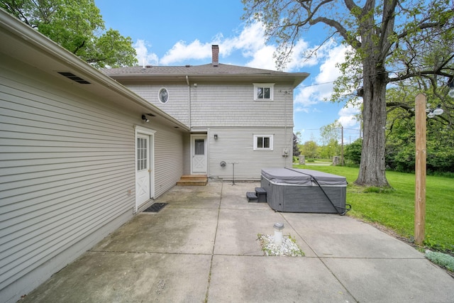 7331 Browns Lake Rd, Jackson, MI 49201 - back of property featuring a hot tub, a patio area, a yard, a chimney, and entry steps