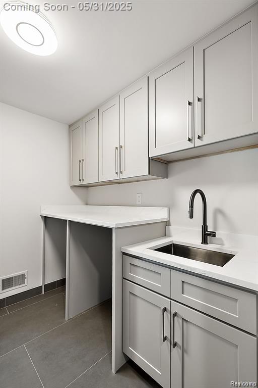 1367 W Long Lake Rd, Bloomfield Hills, MI 48302 - washroom featuring a sink, dark tile patterned floors, and baseboards