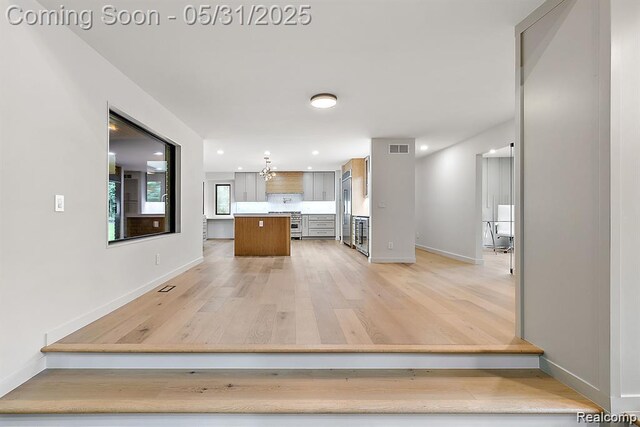 1367 W Long Lake Rd, Bloomfield Hills, MI 48302 - kitchen featuring light wood finished floors, light countertops, baseboards, a kitchen island, and high end refrigerator