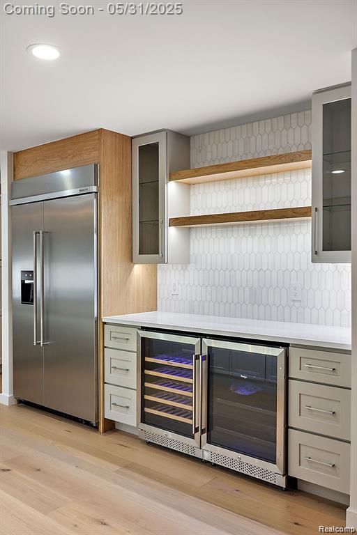 1367 W Long Lake Rd, Bloomfield Hills, MI 48302 - indoor dry bar with built in fridge, decorative backsplash, light wood-type flooring, beverage cooler, and recessed lighting