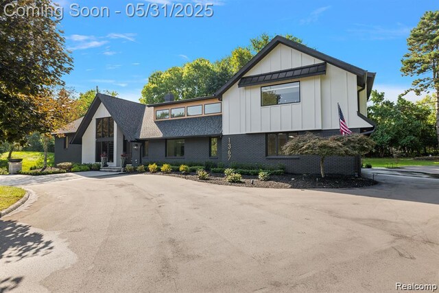 1367 W Long Lake Rd, Bloomfield Hills, MI 48302 - view of front of home with board and batten siding, brick siding, and a shingled roof