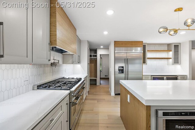 1367 W Long Lake Rd, Bloomfield Hills, MI 48302 - kitchen with premium appliances, custom exhaust hood, light wood-style flooring, tasteful backsplash, and recessed lighting