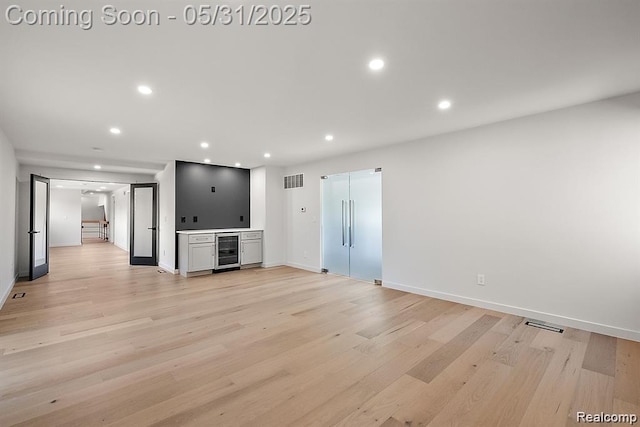 1367 W Long Lake Rd, Bloomfield Hills, MI 48302 - unfurnished living room featuring beverage cooler, light wood finished floors, baseboards, and recessed lighting