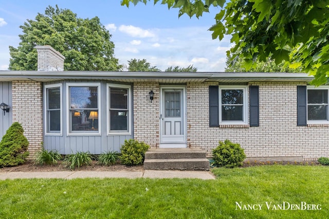 2857 Autumn Ct, Hudsonville, MI 49426 - view of front of home with a front lawn, brick siding, a chimney, and board and batten siding