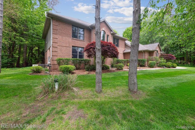 4298 Emu Dr, Pinckney, MI 48169 - traditional-style house featuring brick siding and a front lawn