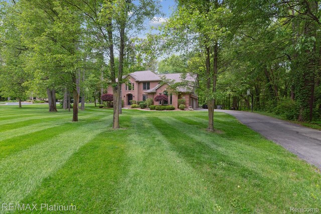4298 Emu Dr, Pinckney, MI 48169 - colonial-style house featuring driveway, a front yard, and an attached garage