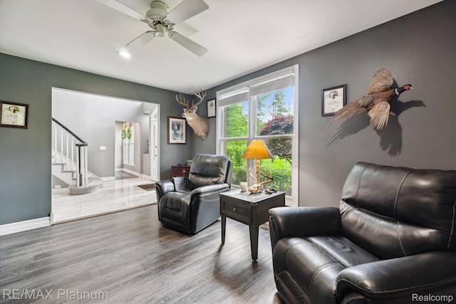 4298 Emu Dr, Pinckney, MI 48169 - living room featuring stairway, ceiling fan, wood finished floors, and baseboards