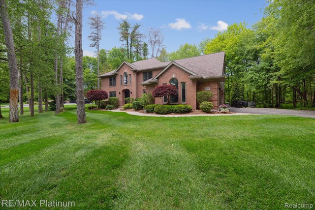 4298 Emu Dr, Pinckney, MI 48169 - view of front of property featuring brick siding, a front lawn, and roof with shingles