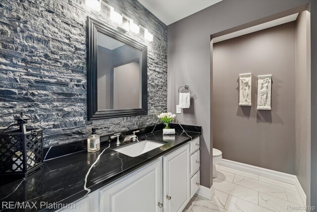 4298 Emu Dr, Pinckney, MI 48169 - bathroom with toilet, baseboards, marble finish flooring, and vanity
