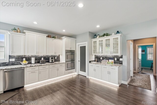 6268 Victoria Ln, Swartz Creek, MI 48473 - kitchen with appliances with stainless steel finishes, decorative backsplash, white cabinets, dark wood finished floors, and glass insert cabinets