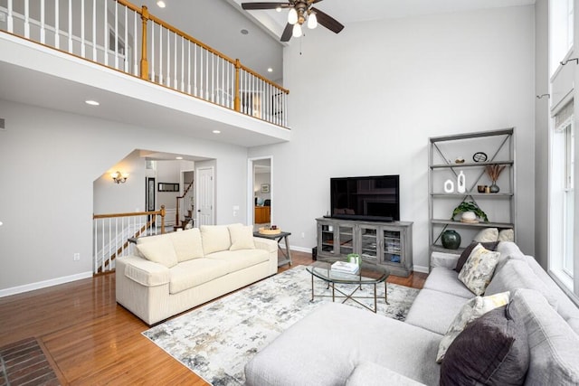 50550 W Fellows Creek Ct, Plymouth, MI 48170 - living area with ceiling fan, a high ceiling, wood finished floors, baseboards, and stairs