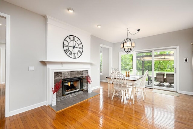 50550 W Fellows Creek Ct, Plymouth, MI 48170 - dining area featuring baseboards, hardwood / wood-style floors, a tiled fireplace, and a chandelier