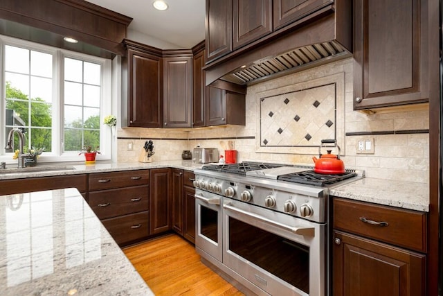 50550 W Fellows Creek Ct, Plymouth, MI 48170 - kitchen featuring range with two ovens, a sink, custom exhaust hood, dark brown cabinets, and backsplash