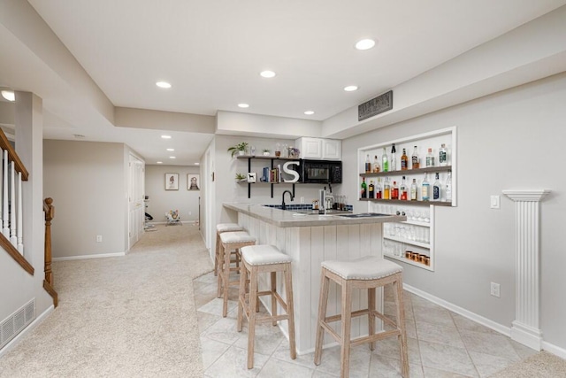 50550 W Fellows Creek Ct, Plymouth, MI 48170 - kitchen with open shelves, a kitchen breakfast bar, black microwave, a peninsula, and recessed lighting