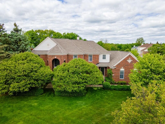 50550 W Fellows Creek Ct, Plymouth, MI 48170 - view of front facade with a front lawn, brick siding, a chimney, and roof with shingles