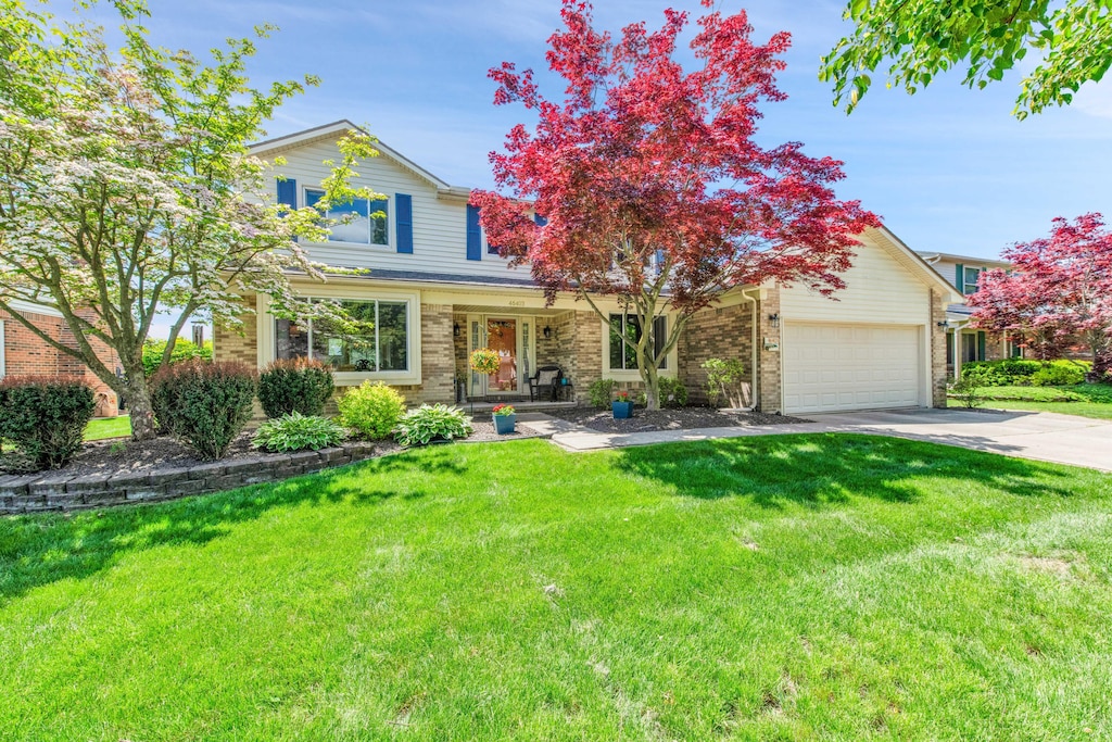 46403 Registry Dr, Canton, MI 48187 - traditional home with an attached garage, a front yard, concrete driveway, and brick siding