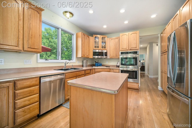 13135 Eagle Ct, South Lyon, MI 48178 - kitchen with appliances with stainless steel finishes, a sink, light wood-type flooring, a kitchen island, and recessed lighting
