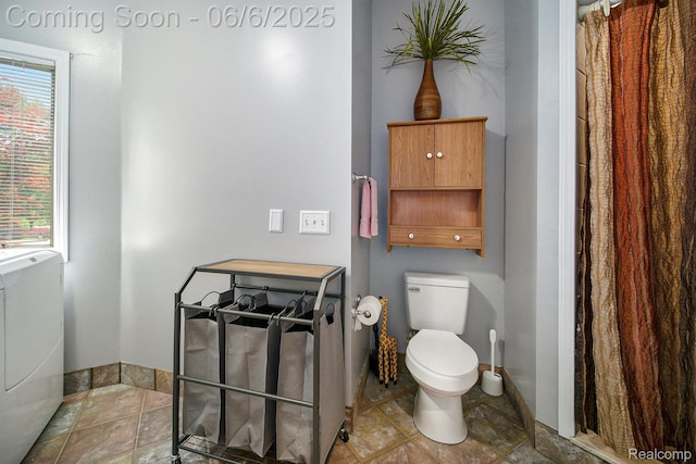 13135 Eagle Ct, South Lyon, MI 48178 - bathroom featuring toilet, healthy amount of natural light, stone finish floors, and washer / dryer