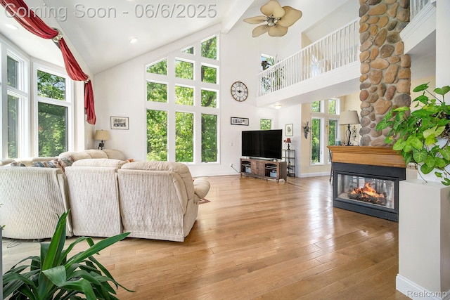 13135 Eagle Ct, South Lyon, MI 48178 - living room with a multi sided fireplace, plenty of natural light, high vaulted ceiling, beamed ceiling, and hardwood / wood-style flooring