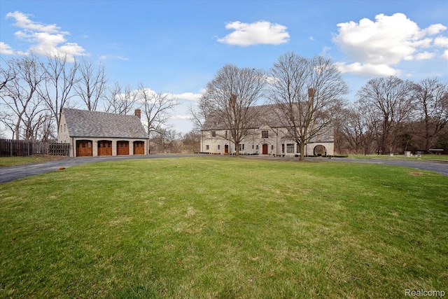 925 Avon St, Flint, MI 48503 - view of front facade with driveway, a chimney, a garage, and an outdoor structure