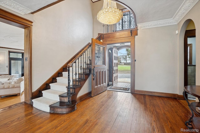 925 Avon St, Flint, MI 48503 - foyer entrance with arched walkways, hardwood / wood-style flooring, baseboards, ornamental molding, and stairway