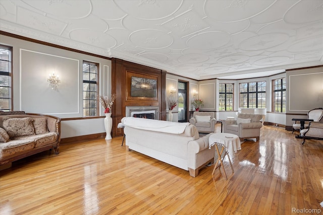925 Avon St, Flint, MI 48503 - living area with ornamental molding, baseboards, light wood-style floors, and a lit fireplace