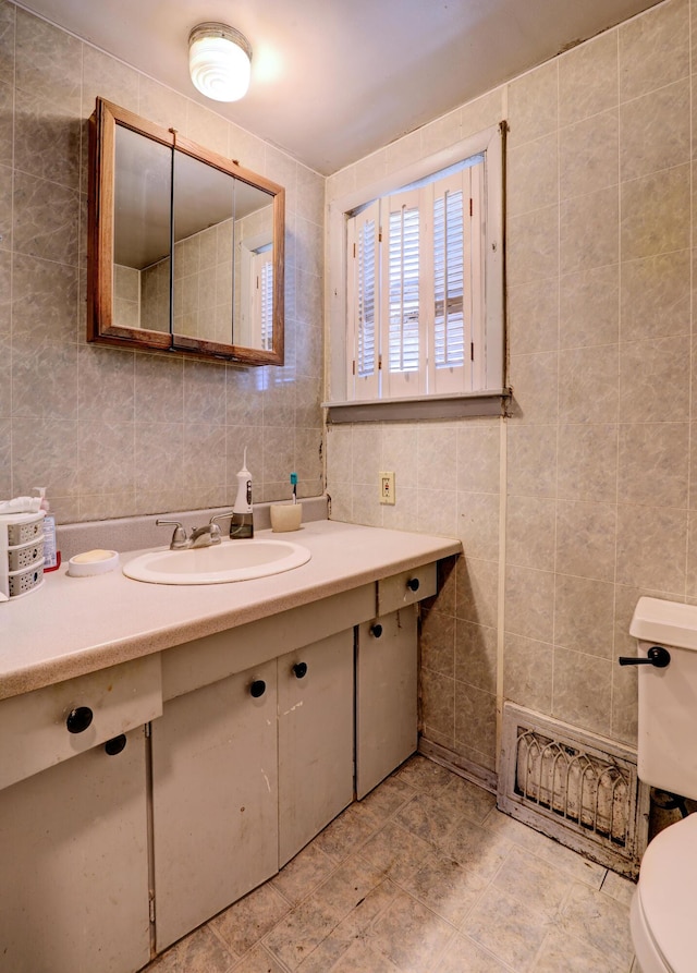 13 W 17th St, Holland, MI 49423 - bathroom with tile walls, toilet, vanity, and tasteful backsplash