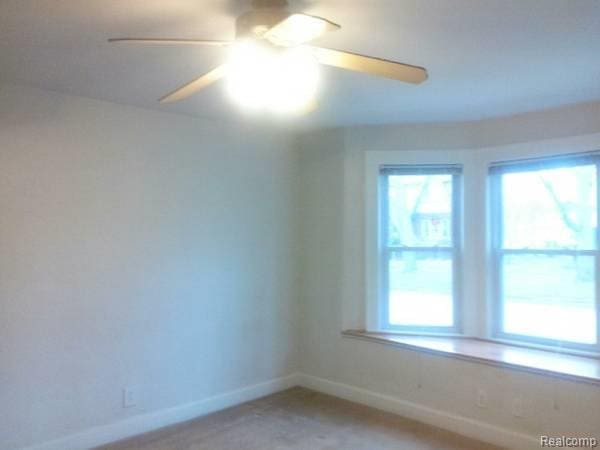 2430 3rd St, Trenton, MI 48183 - spare room with healthy amount of natural light, a ceiling fan, and baseboards