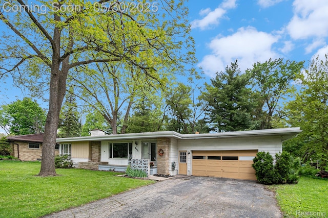 6151 Woodmoor Dr, Burton, MI 48509 - view of front of home featuring a chimney, an attached garage, asphalt driveway, and a front lawn