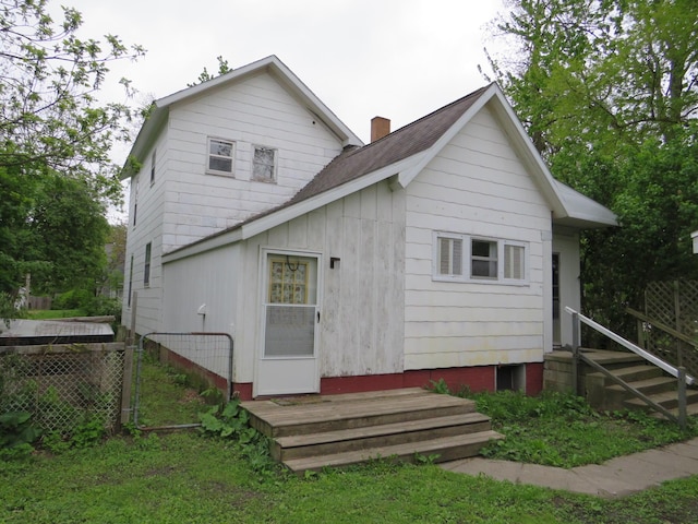 236 S Jeffery Ave, Ithaca, MI 48847 - rear view of property with a chimney, entry steps, and board and batten siding